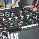 Stół do piłkarzyków jako przykład tradycyjnych benefitów w przestrzeni biurowej.