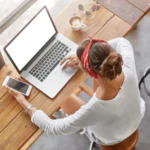 Kobieta pracująca w skupieniu na laptopie - przykład pracy asynchronicznej w domu.